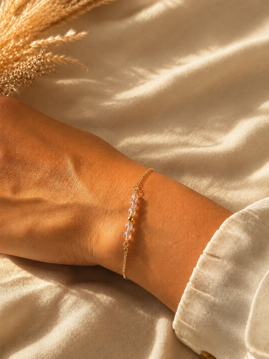 Translation missing: fr.Bracelet doré fin à perles roses irisées, porté au poignet