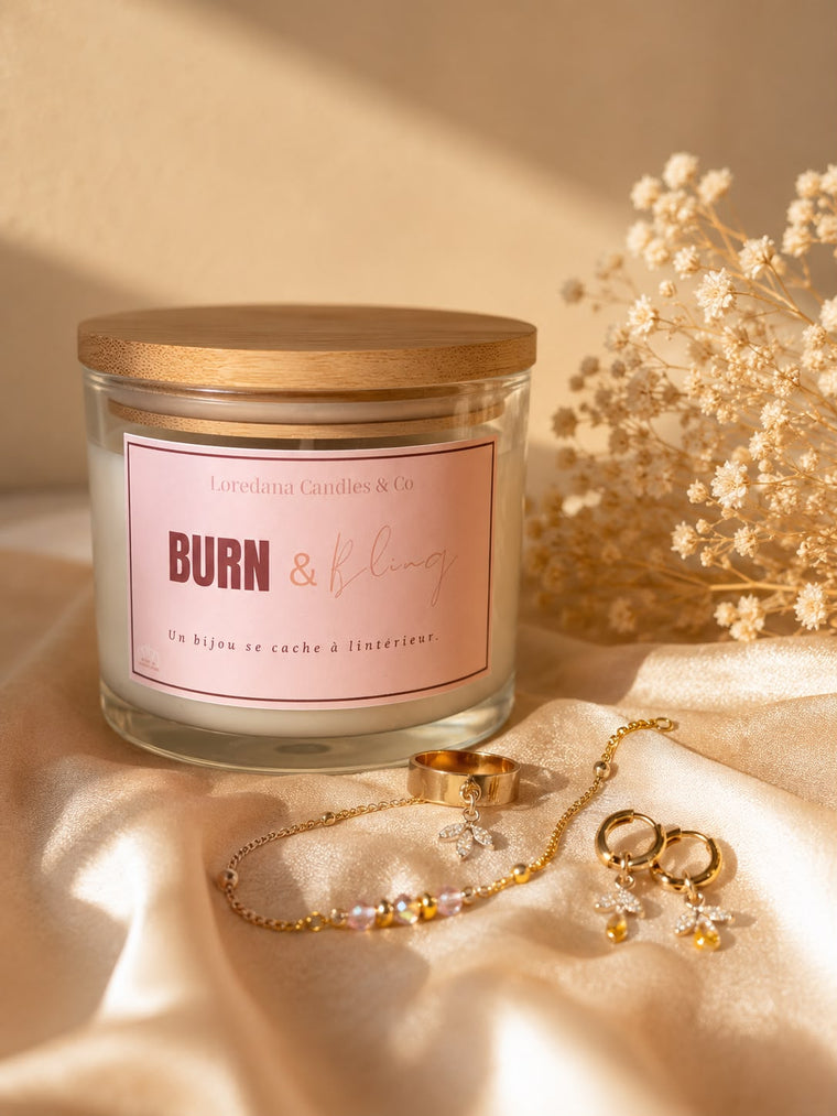 Bougie Burn & Bling de Loredana Candles & Co, pot en verre et couvercle en bambou, étiquette rose, posée près de fleurs séchées